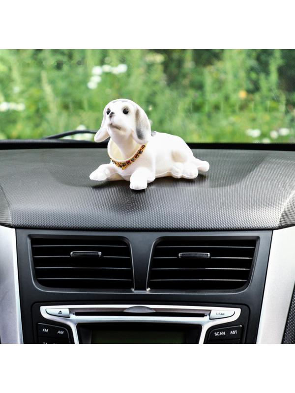 Собака на панель авто, качающая головой, большая, белый окрас