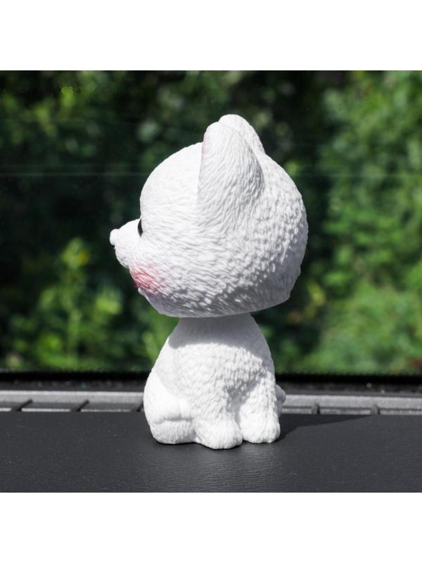 Собака на панель авто, качающая головой, шпиц