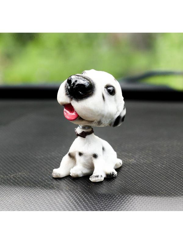 Собака на панель авто, качающая головой, далматин