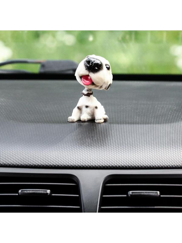 Собака на панель авто, качающая головой, далматин